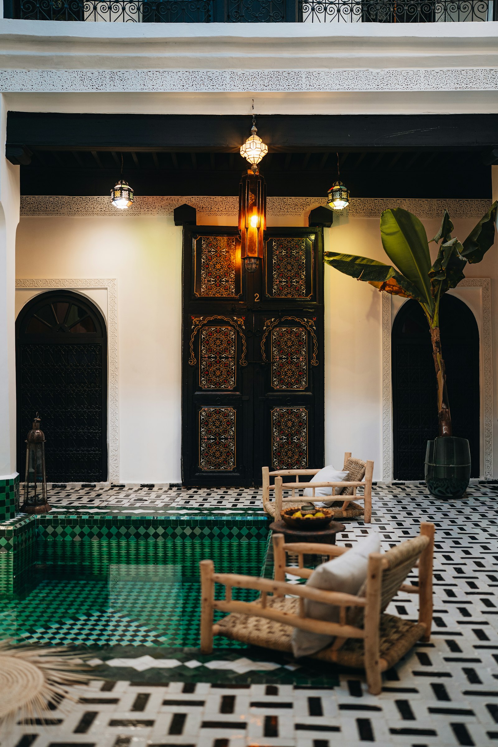 Patio d'un riad avec bassin en zellige vert et porte peinte